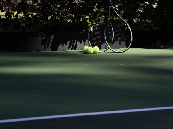 Close-up view of the tennis court, two rackets and balls at our Meadowood Napa Valley resort.