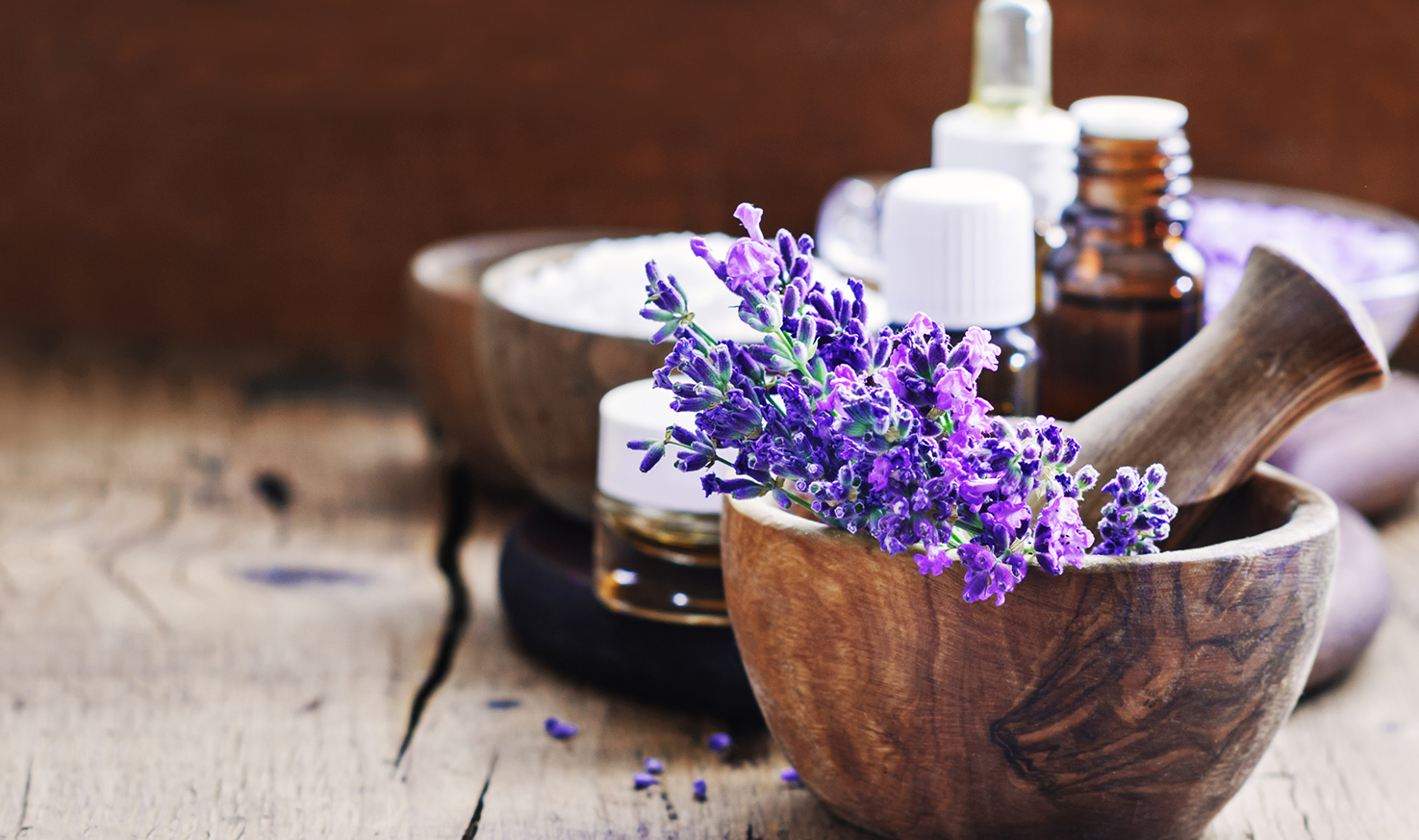 Lavender spa , bunch of lavender flowers , essential oil and salt on a rustic wooden background.