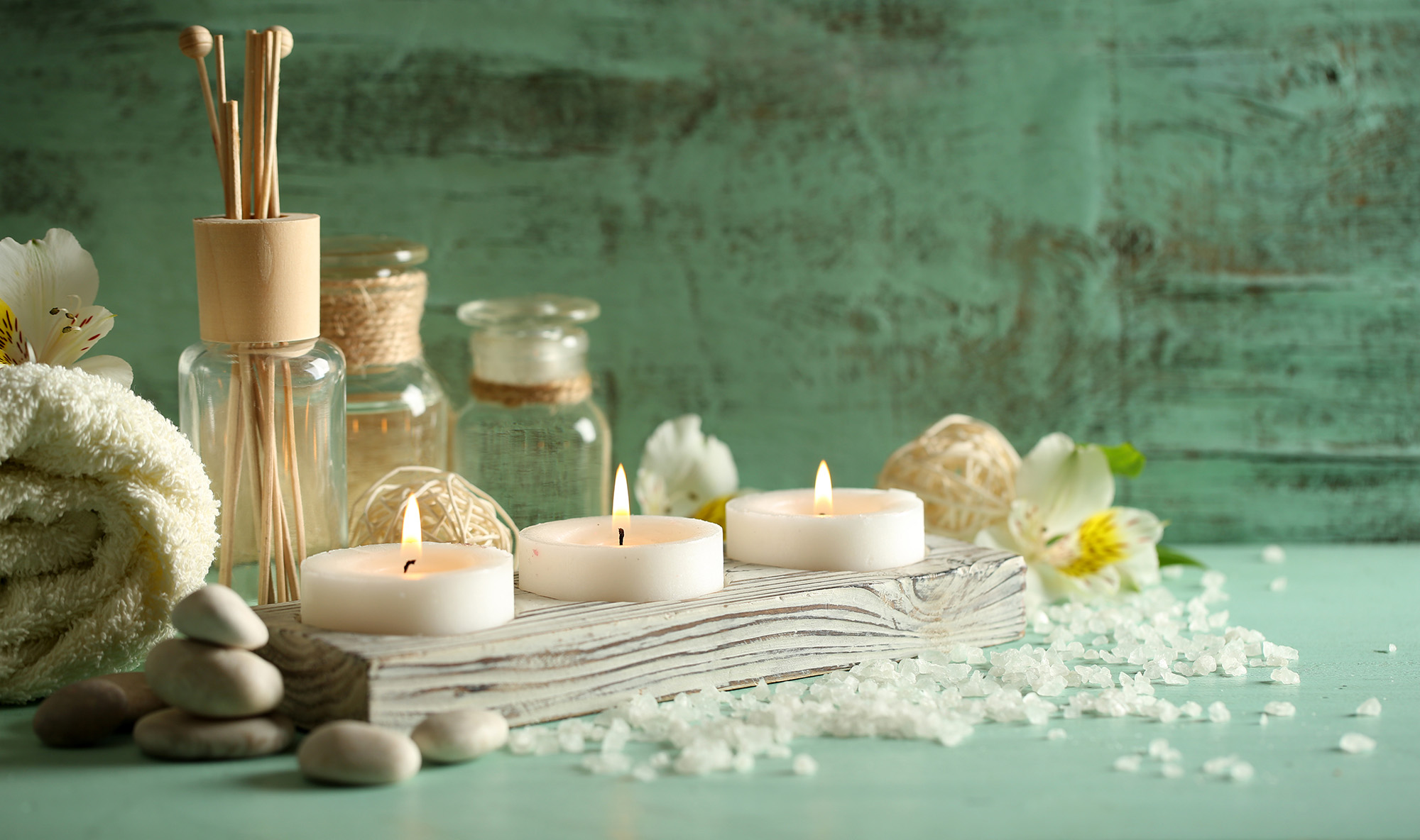 Spa composition with candles, stones, bottles and a towel