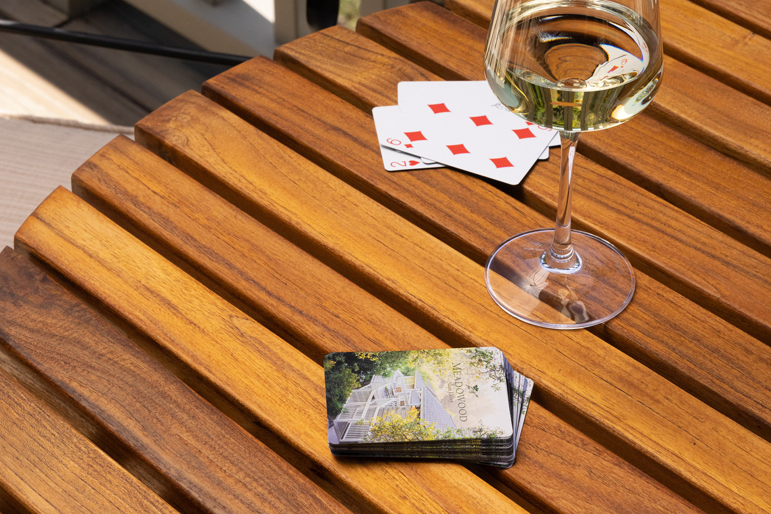 Meadowood playing cards with glass of wine