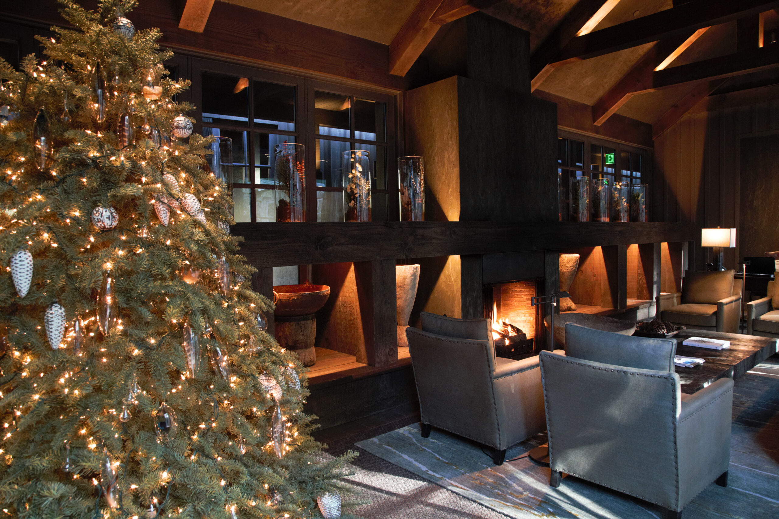 A holiday scene with the living room reception area of Meadowood Spa decorated with a holiday tree showing off lights and ornaments